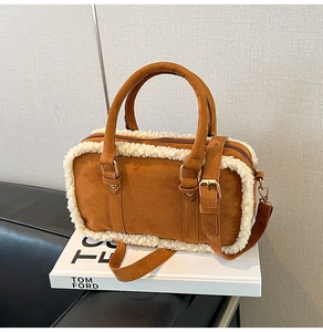 Close-up of brown suede crossbody bag with decorative white faux shearling trim details
