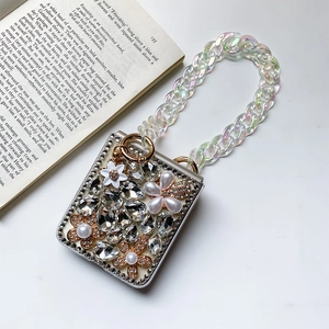 Close-up of luxury rhinestones, pearls, and iridescent chain on a folding phone case