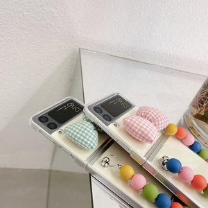 Detail of Galaxy Z Flip case with fabric plaid heart and colorful beaded hand strap