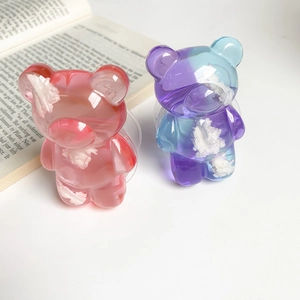 Close-up of pink and blue bear phone socket grips with cute cloud resin details