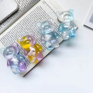 Close-up of four semi-transparent resin bear phone grips with white cloud texture inserts
