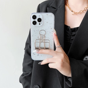 Close-up of clear iPhone case with silver foil and creative gold binder clip stand