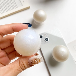 Pearlescent spherical phone grip socket with shimmering shell texture for mobile devices
