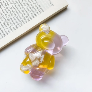 Detail of bear-shaped phone grip with yellow-purple gradient and resin texture