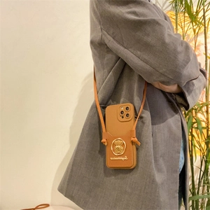 Brown leather phone case with crossbody strap and golden bear emblem detail