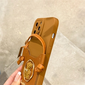 Detailed view of brown leather phone case with bear emblem, card slot and smile text