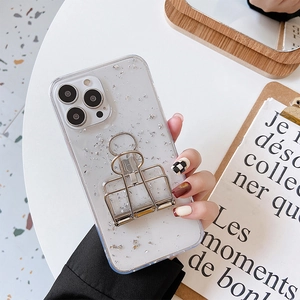 Detailed view of clear iPhone case with silver foil decor and metal clip stand