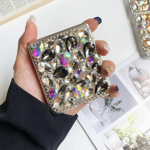 Detailansicht eines luxuriösen quadratischen Handspiegels mit bunten Glitzerkristallen