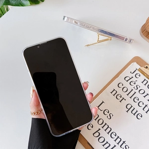 Clear iPhone case with adjustable gold metal kickstand shown on a minimalist white desk