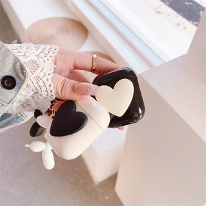 Detail shot of solid color AirPods case featuring a 3D heart design and metal keychain