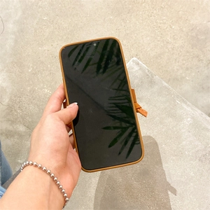 Detail of tan leather iPhone case featuring unique handmade knot decor and slim fit profile