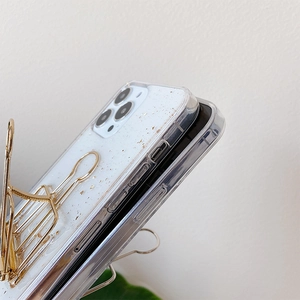 Detail of transparent iPhone case with embedded gold foil flakes and precise port cutouts