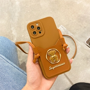 Caramel leather phone case detail with integrated card slot and long crossbody strap