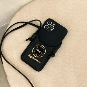 Detail of black leather crossbody phone wallet featuring a metallic 3D bear emblem