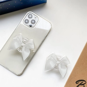 Detail of white fabric bow phone grip socket mounted on a clear case and folded
