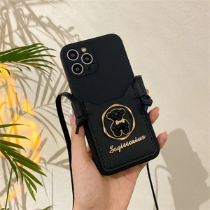 Detail of black iPhone case featuring leather card holder with gold Sagittarius bear charm