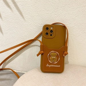 Detailed view of brown leather iPhone case with bear card holder and adjustable strap