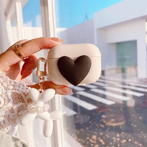 Detailed shot of AirPods case with 3D heart and pearl balloon dog keychain charm