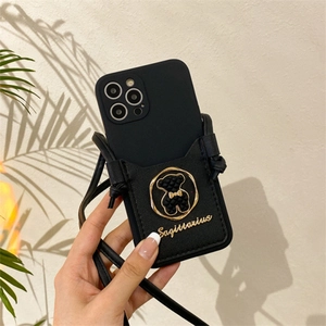 Detail of black iPhone case with leather card holder slot and golden Sagittarius bear charm