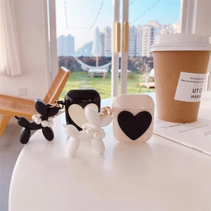 Minimalist heart AirPods case with cute balloon dog charm and pearls in a cafe setting