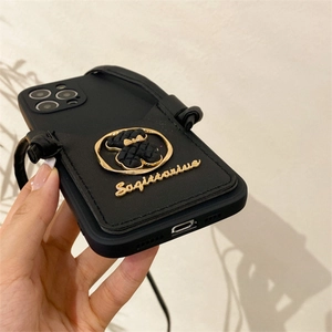 Detail of black leather crossbody phone case with quilted bear logo and Sagittarius text