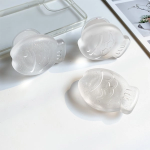 Detailed view of three translucent fish-shaped phone sockets with glitter finish on a desk