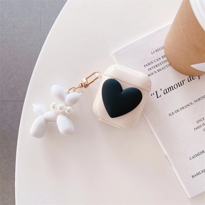 Detailed view of cream AirPods case with black 3D heart and pearl balloon dog charm