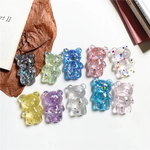 Close-up of ten colorful glitter resin bears in various shades on a white background