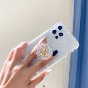Close-up of golden bear phone grip with braided texture and transparent base