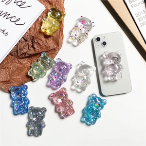 Macro detail of transparent 3D bear phone sockets with colorful glitter and sequins