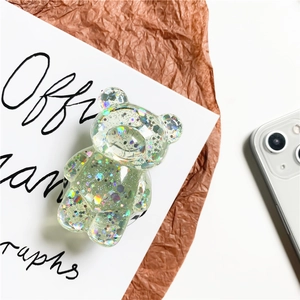 Detail of transparent bear phone grip with holographic sequins and green glitter texture