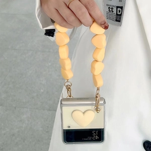 Detail of cream yellow heart-shaped Samsung Z Flip case with matching beaded lanyard