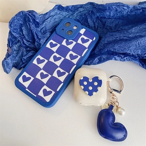 Detail of Klein blue heart AirPods case with leather heart keychain and pearl accessory