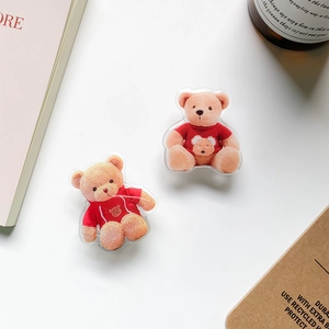 Cute teddy bear phone socket grips on a white desk with aesthetic office props