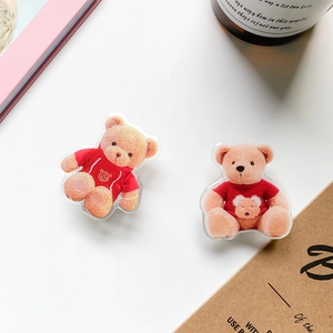 Close-up of cute 3D brown bear phone grip socket accessories on a clean white desk