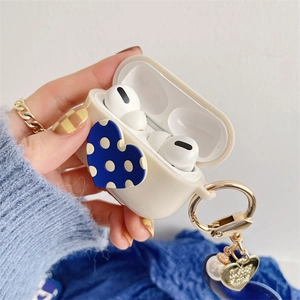Detail of beige silicone case for AirPods Pro featuring blue heart and pearl charm