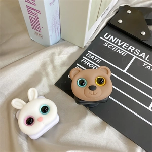 Close-up of cute 3D cartoon bunny and bear expandable phone grips on a desktop
