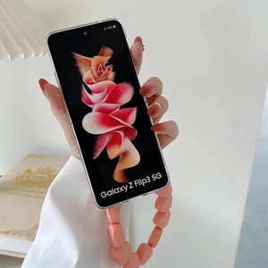 Transparent Galaxy Z Flip3 case with orange-pink matte beaded strap held by a person