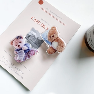 Macro detail of acrylic teddy bear phone socket featuring cute sweater and sleep cap designs