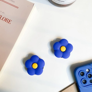Gros plan d'un support de téléphone fleur bleue mat avec centre jaune sur une coque assortie