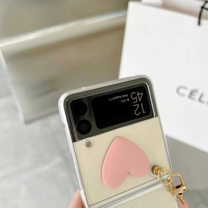 Detail of transparent foldable phone case with pink heart grip and gold metal ring