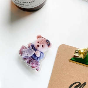 Close-up of the cute acrylic teddy bear phone grip with a high-gloss finish on a white table