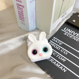 Close-up of cute rabbit flip mirror phone grip on silk fabric with soft lighting