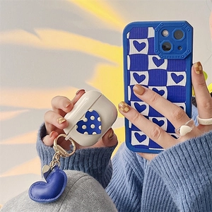 Blue and white checkerboard iPhone case with matching AirPods Pro cover and heart charm