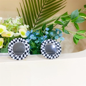 Detail view of a checkerboard pattern phone grip with a reflective round mirror surface