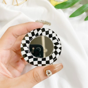 Macro shot of a round checkerboard phone socket with an integrated makeup mirror detail