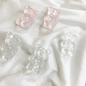 Close-up of pink and pearl white bear phone grips with crystal cut resin texture