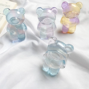 Set of four colorful gradient resin gummy bears on white fabric with a clean aesthetic