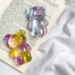 Macro detail of gradient bear phone stands with iridescent finish on open book pages