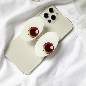 Detail of creative cartoon big eyes expanding phone socket on a white smartphone
